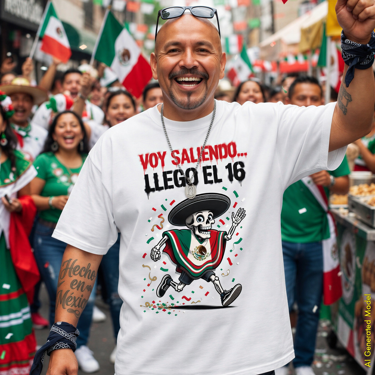 A smiling man wearing a white relaxed Fit Comfort Colors 1717 graphic T-shirt stands in a crowded street scene with many Mexican flags and people around him. The shirt has red text reading 'VOY SALIENDO...llego el 16.